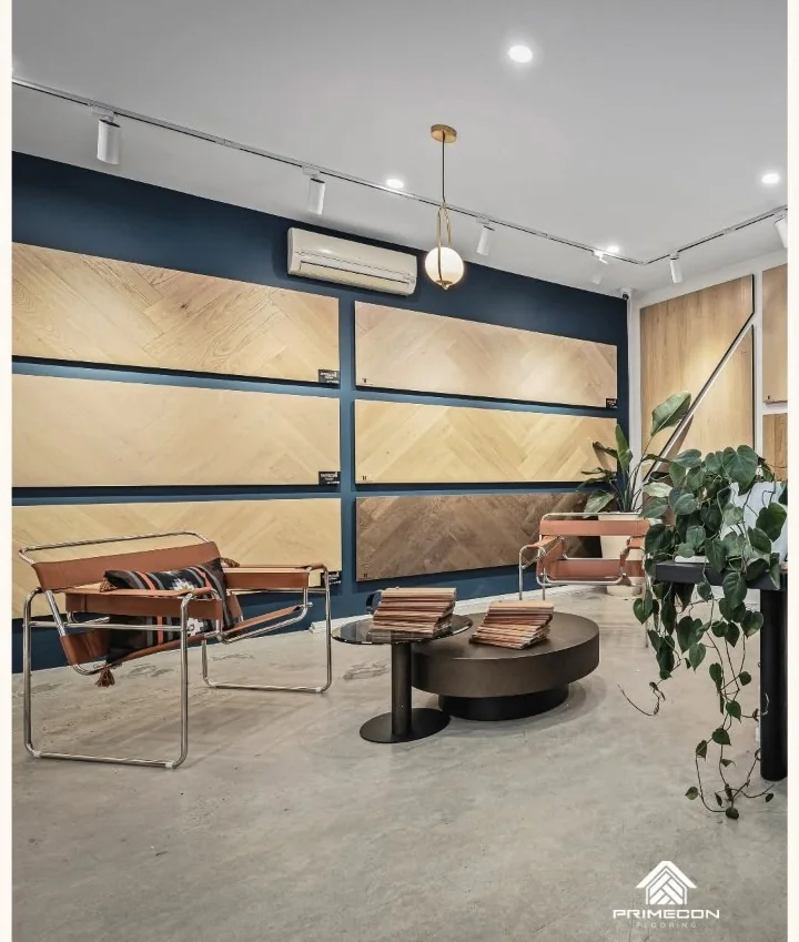 Lounge area in the Primecon Flooring Camberwell showroom, with oak herringbone display panels on a navy wall